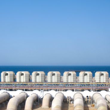 Industrial facility with large pipes and cooling units, showcasing Hyosung’s top-rated infrastructure solutions