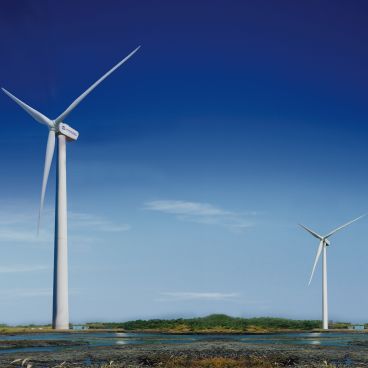 Wind turbines spinning in an open landscape, reflecting Hyosung’s role in advancing clean energy through wind, solar, and hydrogen technologies