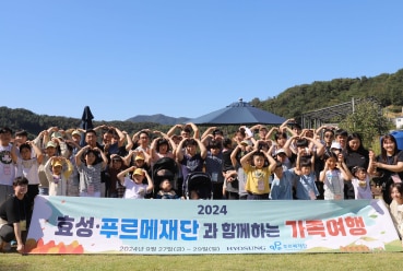 효성이 후원하는 장애 어린이 지원 행사에서 참가자들이 현수막 뒤에 모여 머리 위로 손을 들고 단체 사진을 찍는 모습