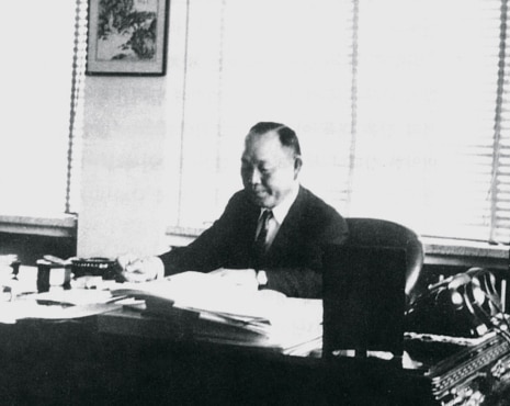 Founder Cho Hong-je planning business strategy while reviewing documents at his office desk